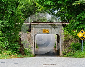 Single lane underpass road short tunnel under a railroad track.