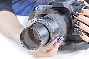Single-lens reflex camera in the hands of a girl