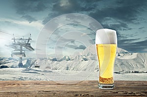 Single light beer in glass and landscape of mountains on background