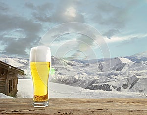 Single light beer in glass and landscape of mountains on background