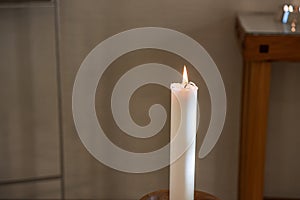 Single lit candle light in a church..