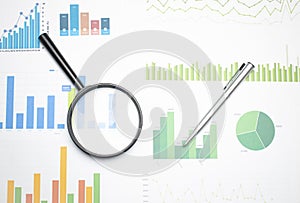 Single Magnifying Glass with Black Handle, Leaning on the financial data. Concept of Business and Finance research