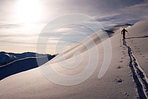 Single male backcountry skier climbing a snowy ridge near Klosters