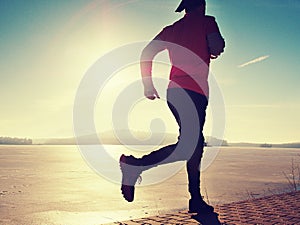 Single man running workout, excercise for run near frozen lake