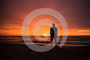 Single man watching a dramatic sunset by the sea