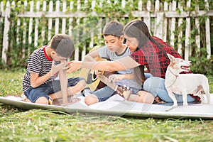 Single mom and sons play guitar together in the park