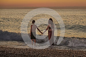 Single mother on the beach with son at sunrise