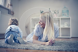 Single mother have play in living room with her baby boy.