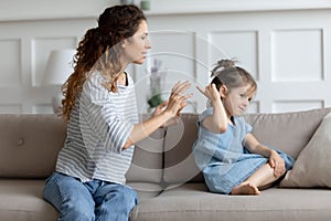 Young mother scolding naughty little misbehave daughter photo