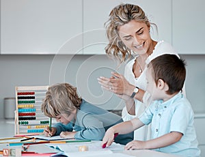 Single mother teaching little sons during homeschool class at home. Autistic cute little caucasian boys learning how to photo