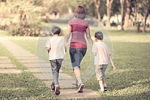 Single mother walking in the park with sons