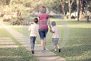 Single mother walking in the park with sons