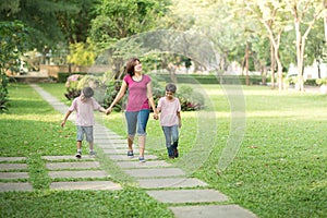 single mother walking in the park with sons happy