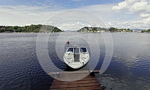 Single motorboat tied to dock in Oslo Fjord.