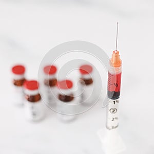 Syringe of medicine with vials of medicine photo