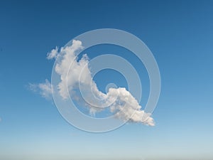 A single, odd shaped, clouds drifts across blue sky, panorama format