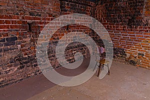 Single, old chair against old brick wall