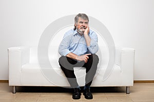 Single old men on white couch