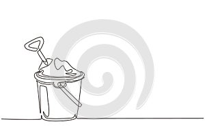 Single one line drawing Bucket and spade. Sand in bucket with shovel. Summer plastic kid toy. Sand bucket and shovel