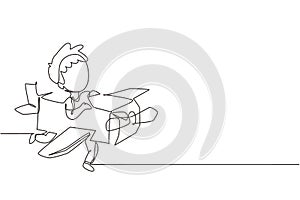 Single one line drawing creative boy playing as pilot with cardboard airplane. Happy kids riding cardboard handmade airplane.