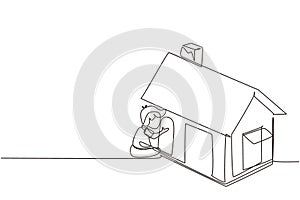 Single one line drawing cute little boy playing in house made of cardboard boxes. Creative child sitting in playhouse. Kid leisure