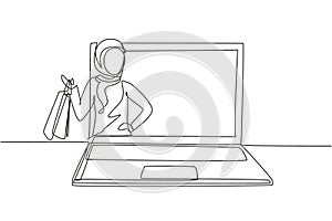 Single one line drawing young Arabian woman coming out of laptop screen holding shopping bags. Digital lifestyle and consumerism