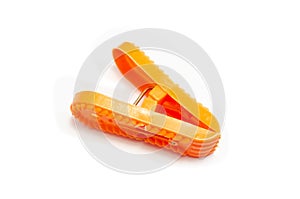 Single orange plastic clothespin cloth peg on white background