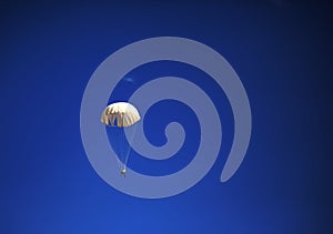 Single parachute jumper against blue sky background