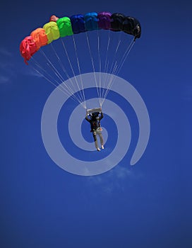 Single parachute jumper against blue sky background