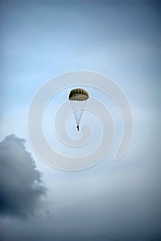 Single parachute jumper against blue sky background