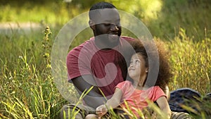 Single parent father taking care of treasured little daughter with curly hair photo