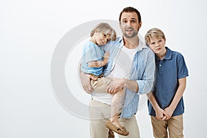 Single parent looking after sons. Dad holding cute child with vitiligo while staring nervously at camera, being left photo