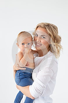 Single parent, motherhood and baby concept - Cheerful mother having fun with her little daughter in the studio, isolated