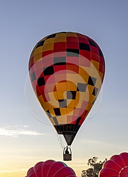 Single person hot air balloon taking off at sunrise