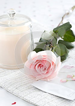 Single pink rose with face mask and candle