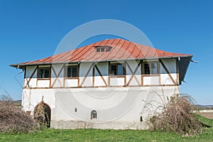 Single plain house with intersting wood beans walls and hills in the background photo