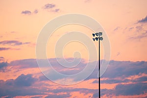 Single pole or column of spotlight or stadium light in arena with sunset beautiful sky and with copy space