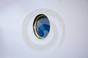 Single porthole on a white wall on a ship
