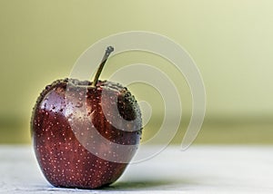 Single red apple with sprinkles of water