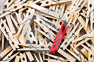 Single red clothespin on a pile of ordinary colored ones/abstract individuality, uniqueness concept