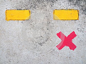 single red paint cross marks on cement floor of train station platform with yellow dividing line