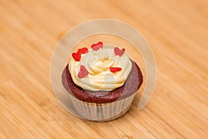 Single red velvet cupcake decorated with buttercream.