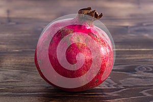 Single ripe pomegranate fruit on the table