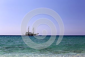 Single sailing ship at open sea under clear sky