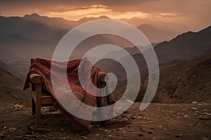 single seat with a pashmina shawl draped over it, mountains in the distance photo