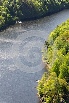 Single ship and lonely pier on river, breathtaking green woods nature landscape, sunny summer day, Vltava, Slapy reservoir