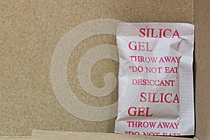 Single Silica gel packet in the bottom corner of a cardboard box.