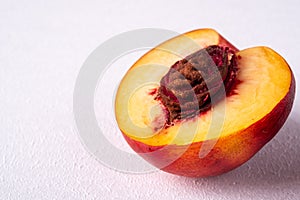 Single slice of peach nectarine fruit with seed on white background, copy space, angle view