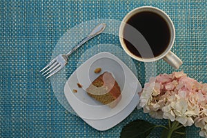 Single slice of Rum cake with coffee mug and Hydrangea flower