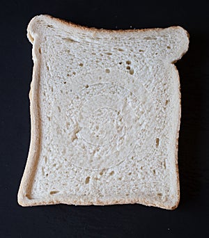 A slice of white bread on a black background photo